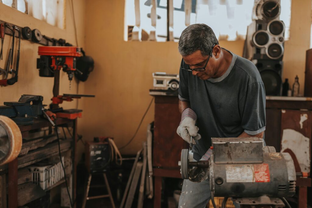 A skilled artisan focuses on metalwork with precision tools in a workshop.